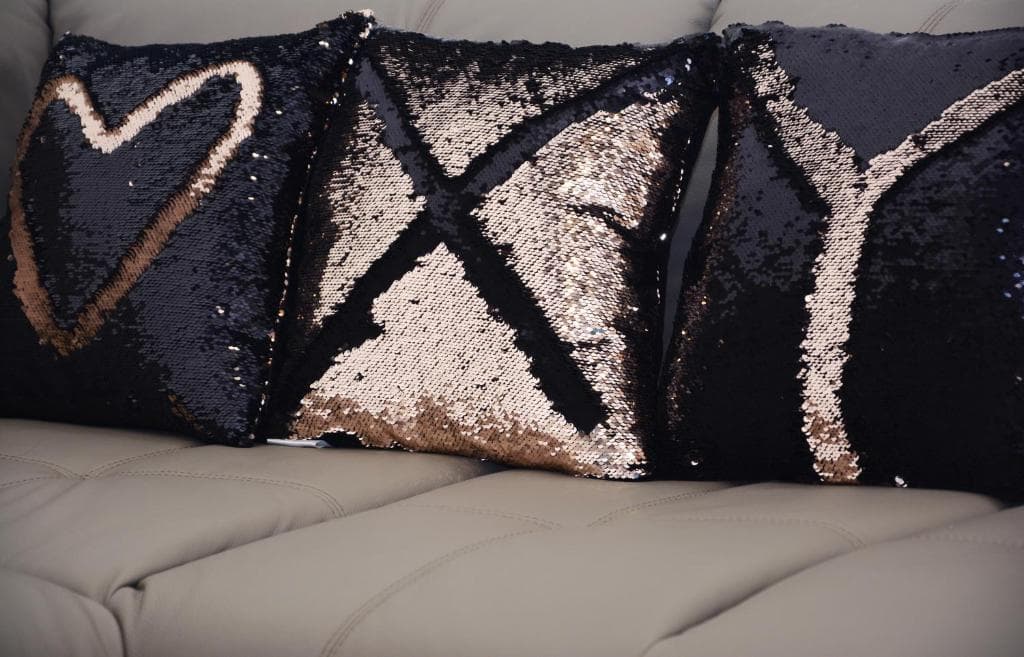 Sequinned cushions on a sofa in Design Apartment X, showing a heart, an X and a Y